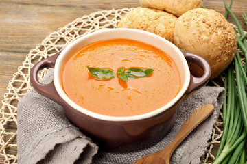 Carrot cream-soup with buns on table close up