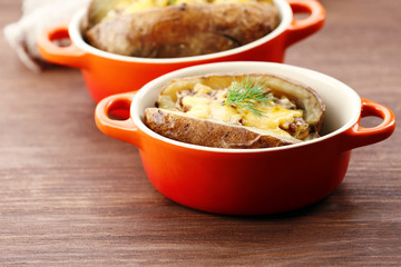 Baked potatoes with cheese and mushrooms on table close up