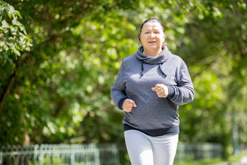 Mature woman jogging in the park. Healthy lifestyle