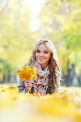 Woman lying in autumn leaves