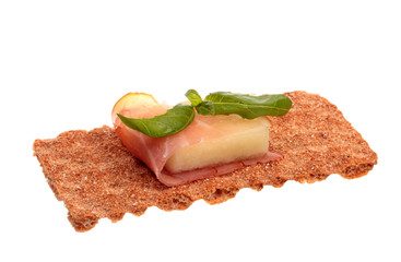 Parma ham with melon and basil on a rye crisp