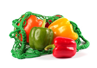 Fresh  sweet peppers in a green string bag