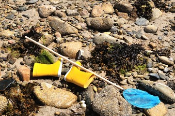 Equipement d'enfant pour la pêche à pied en bord de mer abandonné sur des cailloux