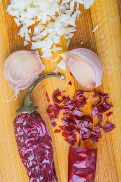 Garlic and hot pepper, hot spices on wooden cutting board