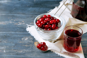 Sweet homemade cherry juice on table, on color wooden background