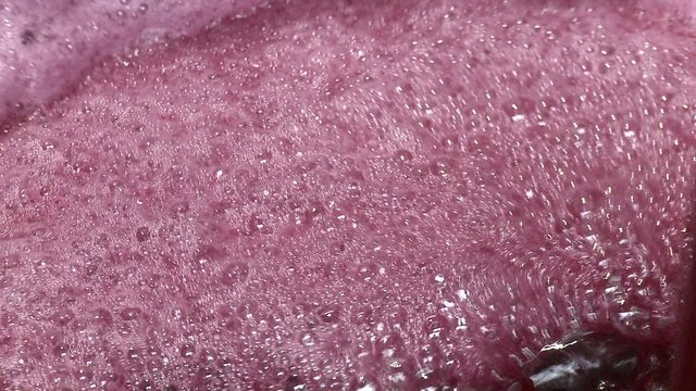 Close-up of red wine being pumped over from one fermentation tank to another.