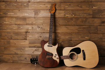 Electric and acoustic guitars on wooden background