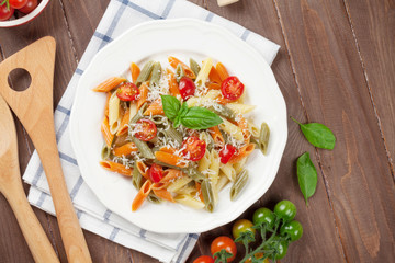 Colorful penne pasta with tomatoes and basil