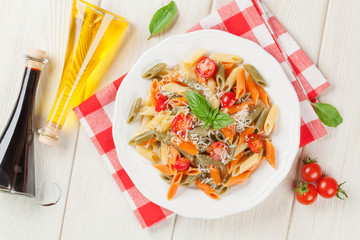 Colorful penne pasta with tomatoes and basil