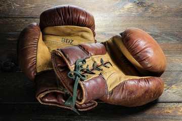 alte Boxhandschuhe auf rustikalem Holzhintergrund
