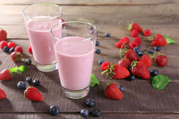 Glasses of berry smoothie on wooden table, closeup