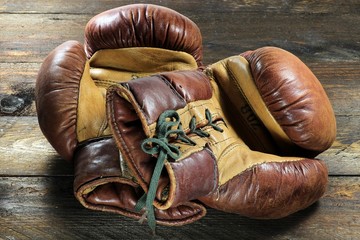 alte Boxhandschuhe auf rustikalem Holzhintergrund
