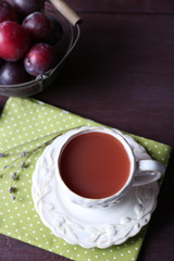 Delicious plum juice with fruits on wooden table close up