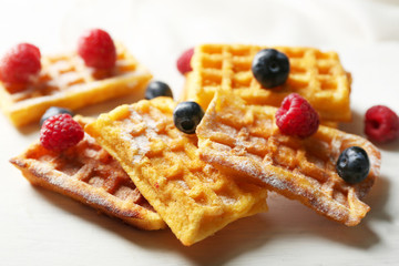 Sweet homemade waffles on tray, on light background