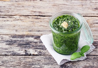 Basil pesto on a rustic wooden table.Selective focus 