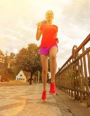 Running woman during sunny day in the city.