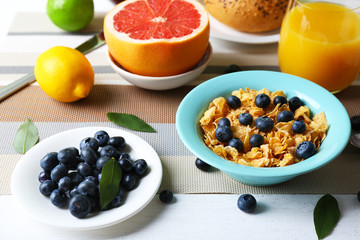 Tasty cornflakes with fruits and berries on table close up