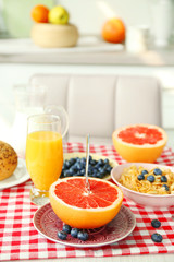 Healthy breakfast with fruits and berries on table in kitchen