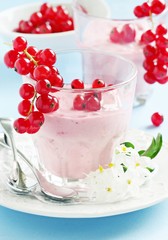 Homemade yogurt with red currants on a light blue background.Selective focus 