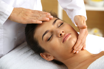 Young woman in beauty spa salon enjoying head massage