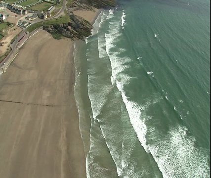 cu of surf on beach, then tilt up to sea 