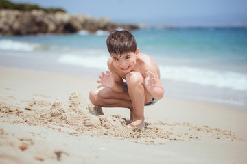 Child playing with the sand on a beach