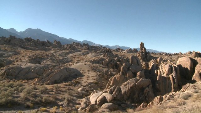 Pan across the granite rock formations of the Alabama Hills and the Sierra Nevada Range above Lone Pine, California.