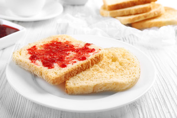 Bread with homemade jam in plate on wooden table, closeup
