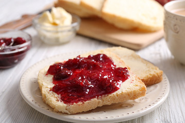 Bread with butter and homemade jam on wooden table, closeup