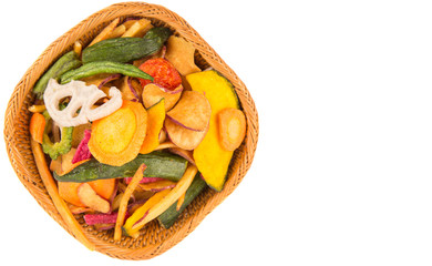 Mix vegetable chips in a wicker bowl over white background