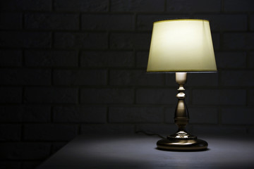 Old fashion table lamp on table on brick wall background