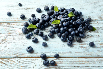 Fresh blueberries with mint on wooden table close up
