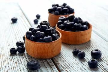 Fresh blueberries in bowls on table close up