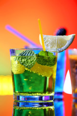 Glasses of cocktails on bright background