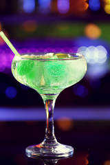 Glass of cocktail on bar background