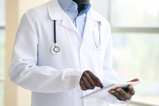 Handsome African American Doctor Holding Digital Tablet In Hospital