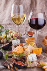 Grape, cheese, figs and honey with a glasses of red and white wine.Cheese Board.selective focus