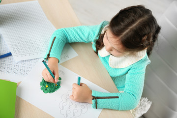 Cute little girl doing her homework, close-up