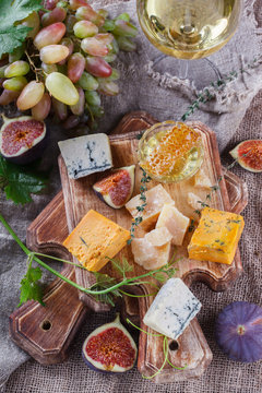 Grape, cheese, figs and honey with a glasses of red and white wine.Cheese Board.selective focus