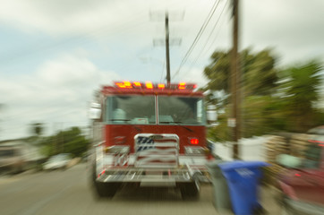 Fire Engine on city street, with sirens on. Motion blurred to imply tension and action.
