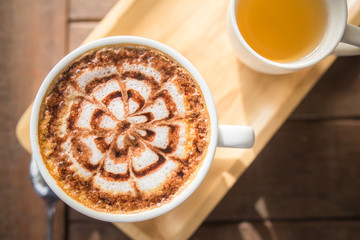 Latte Coffee art on the wooden desk with tea cup