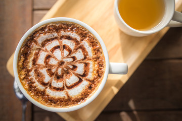 Latte Coffee art on the wooden desk with tea cup