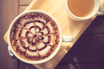 Latte Coffee art on the wooden desk with tea cup vintage color