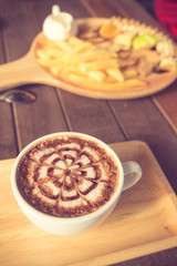 Fototapeta na wymiar Latte Coffee art on the wooden desk vintage color