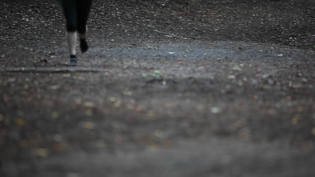 A woman seen jogging from below the waist.