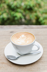 Cup of hot coffee latte art on wood table