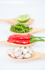 Ingredients of thai food on wooden spoon (chili, pepper, garlic