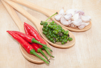 Ingredients of thai food on wooden spoon (chili, pepper, and garlic