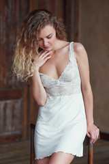 Fototapeta premium Indoor portrait of young blond sexy woman in sleepwear