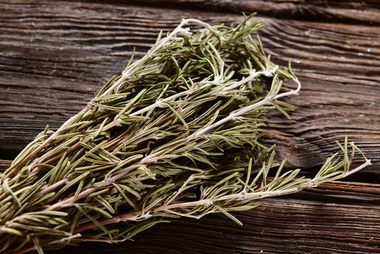Dry rosemary on wooden background
